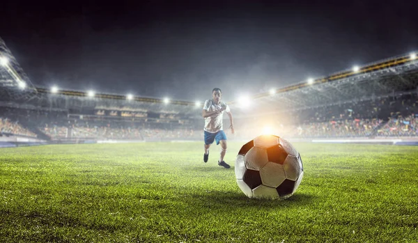 Jogador de futebol em ação. Meios mistos — Fotografia de Stock