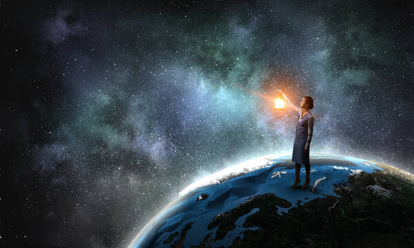 Young woman with lantern standing on Earth planet. Elements of this image are furnished by NASA