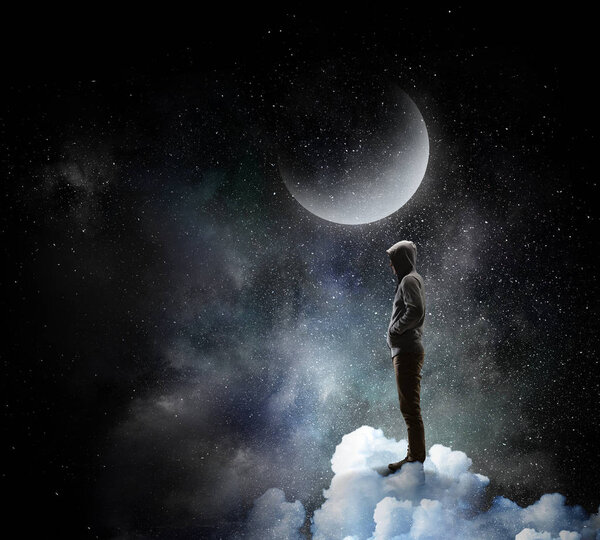 Young man in hood against night sky background