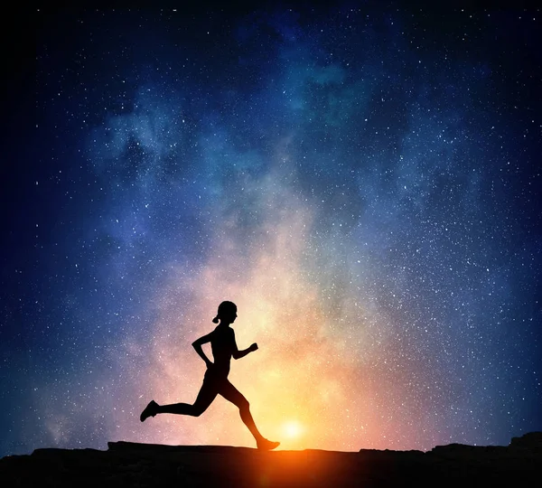 Um corredor a correr à noite. Meios mistos — Fotografia de Stock