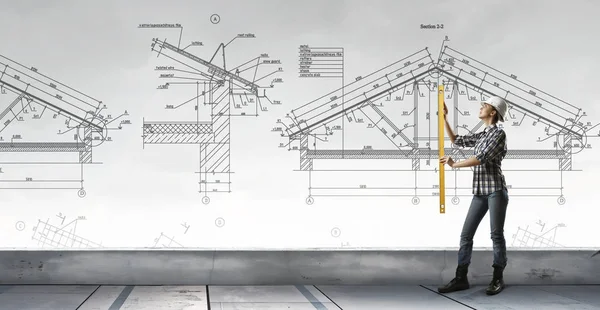 Mujer constructora tomando medidas. Medios mixtos —  Fotos de Stock