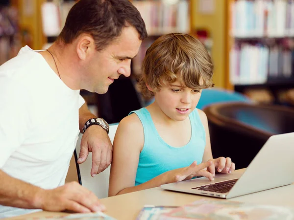 Menino e seu pai com laptop — Fotografia de Stock