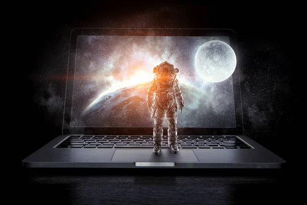 Space explorer and laptop. Mixed media — Stock Photo, Image