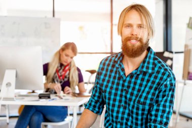 Genç adam ofiste çalışıyor.