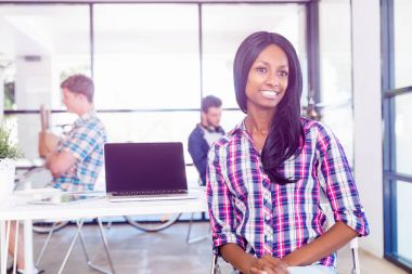 Afro-Amerikan ofis çalışanı iş içinde onun meslektaşları ile gülümseyen portresi