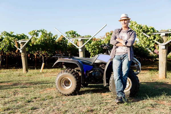 Uomo in piedi accanto al camion in vigna — Foto Stock