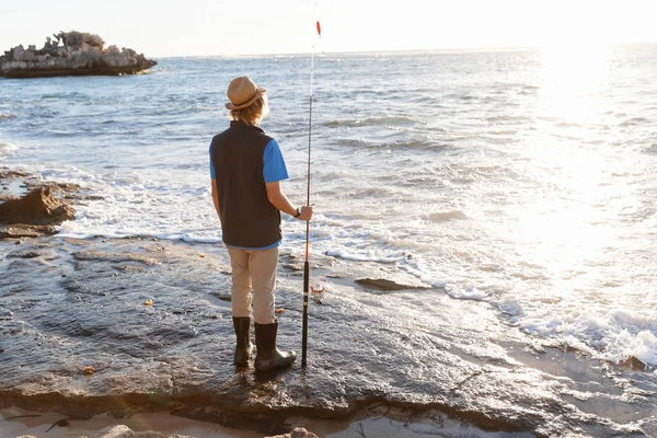 Мальчик-подросток рыбачит в море — стоковое фото
