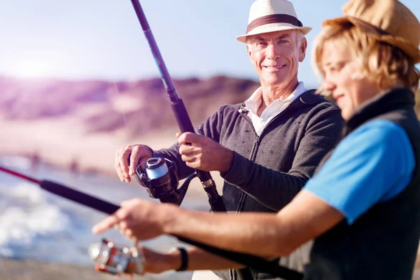 Uomo anziano pesca con suo nipote — Foto Stock