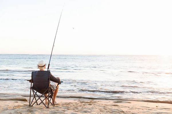 Senior man fishing at sea side — Stock Photo, Image