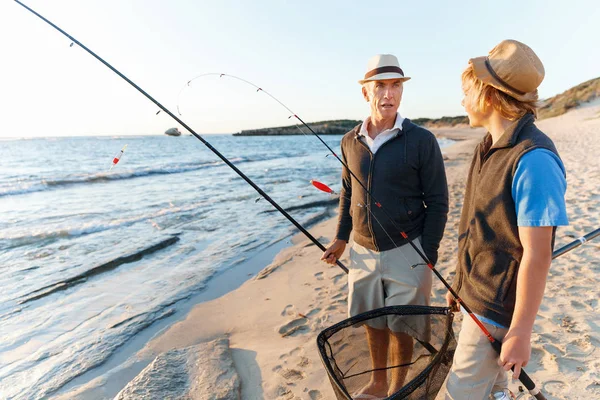 Uomo anziano pesca con suo nipote — Foto Stock