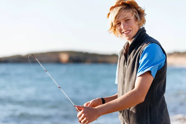 Teenage boy fishing at sea — Stock Photo, Image