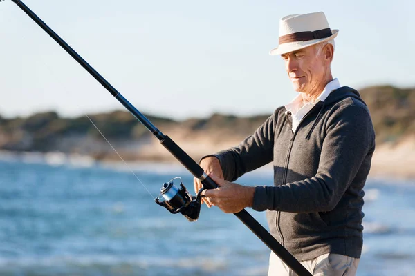 Homme âgé pêche au bord de la mer — Photo