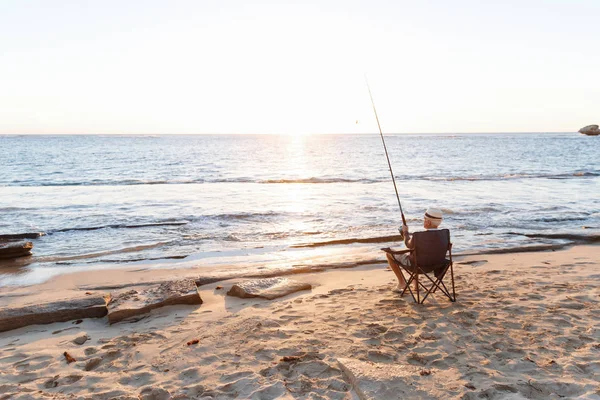 Hombre mayor pescando en el lado del mar — Foto de Stock