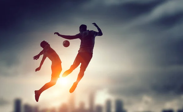 Silhouettes of two soccer players — Stock Photo, Image