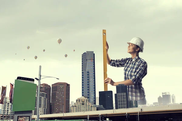 Mujer constructora tomando medidas. Medios mixtos — Foto de Stock