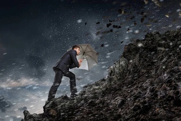 Businessman with black umbrella. Mixed media — Stock Photo, Image