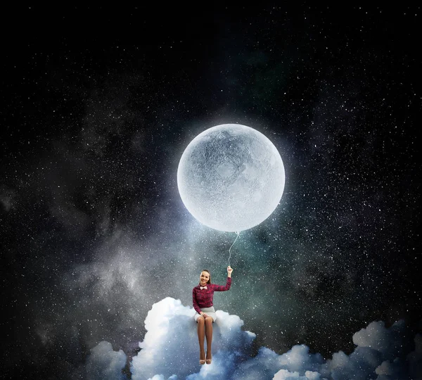 Woman sitting on cloud . Mixed media — Stock Photo, Image