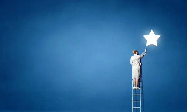 Geschäftsfrau auf Leiter erreicht Stern — Stockfoto