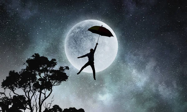 bulutlu bir günde uçan şemsiye ile işadamı