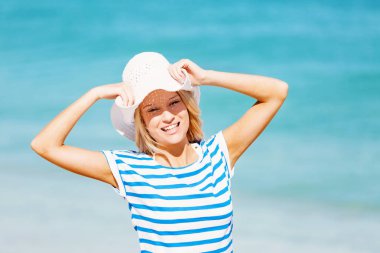 Genç bir kadın sahilde dinleniyor.