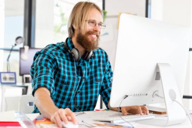 Genç adam ofiste çalışıyor.