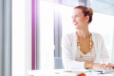 Çekici ofis çalışanı masada oturuyor.