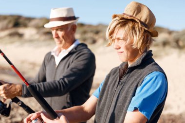 Yaşlı adam torunuyla balık tutuyor.