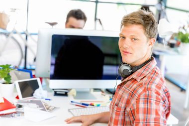 Genç adam ofiste çalışıyor.