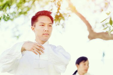 Yakışıklı adam Thai Chi yapıyor.