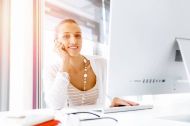 Çekici ofis çalışanı masada oturuyor.