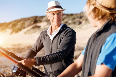 Yaşlı adam torunuyla balık tutuyor.