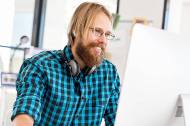 Genç adam ofiste çalışıyor.