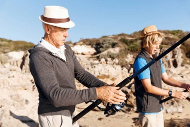 Yaşlı adam torunuyla balık tutuyor.