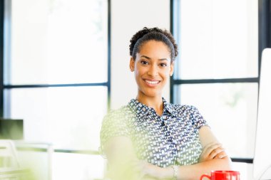 Afro-Amerikan ofis çalışanı iş içinde oturan gülümseyen portresi