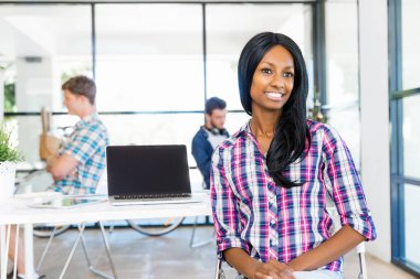 Afro-Amerikan ofis çalışanı iş içinde oturan gülümseyen portresi
