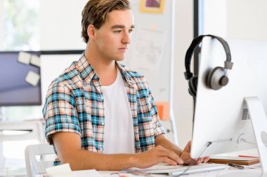 Genç adam ofiste çalışıyor.