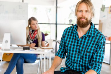 Genç adam ofiste çalışıyor.