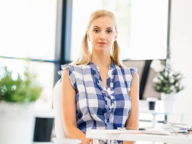 Genç bayan ofiste çalışıyor.