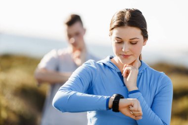 Kalp atış hızı monitörünü plajda çalışan kadınla Runner