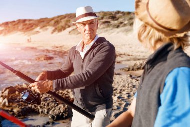 Yaşlı adam torunuyla balık tutuyor.
