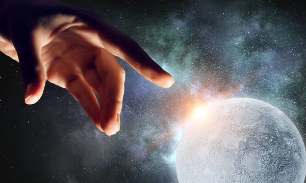 Рука касается луны — стоковое фото