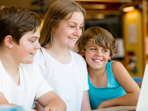 Three kids in library — Stock Photo, Image