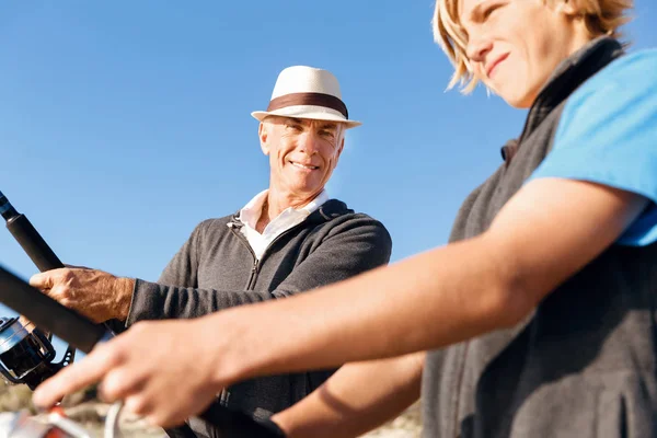 Senior man vissen met zijn kleinzoon — Stockfoto