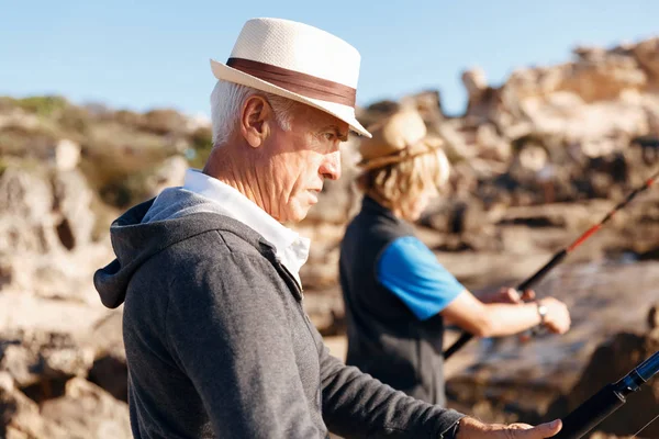 Senior man vissen met zijn kleinzoon — Stockfoto