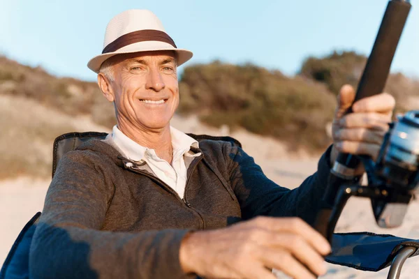 Senior man fishing at sea side — Stock Photo, Image