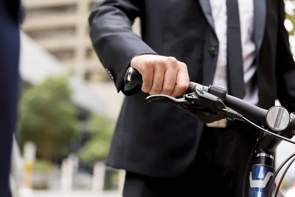 Homens de negócios jovens com uma bicicleta — Fotografia de Stock