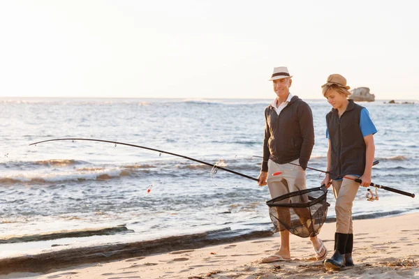 Hombre mayor pescando con su nieto — Foto de Stock