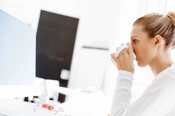 Atraktivní kancelářský pracovník sedící za stolem — Stock fotografie