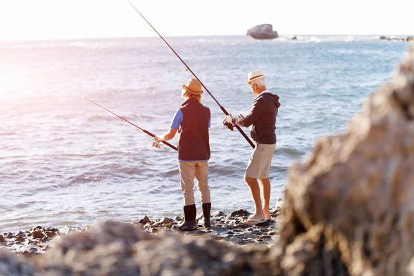 Uomo anziano pesca con suo nipote — Foto Stock