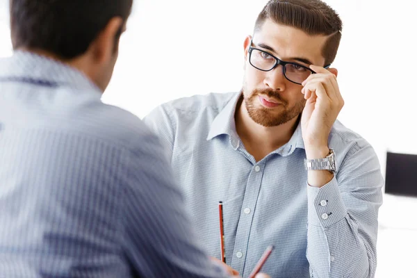 Ofiste iki yakışıklı işadamı var.